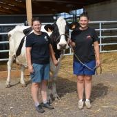 Émeline (à g.) et Marcelline Clauss avec Malibu Coco, l’une des trois vaches qui va participer au concours Prim’Holstein. Photo : H.Flamant 